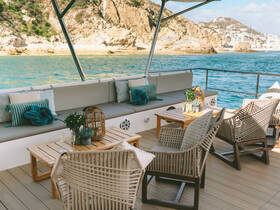 A beautifully designed lounge area on a boat, featuring comfortable seating and a scenic view of the water, perfect for relaxing during a day on the sea.