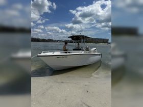 Two individuals enjoy their time aboard a boat anchored in shallow waters, perfect for a day of relaxation and fun on the water.