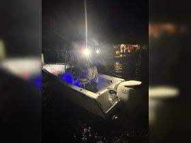 A well-lit boat docked at night, showcasing its sleek design and vibrant lighting — perfect for evening outings on the water.