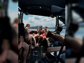 A lively group enjoys a summer day aboard a boat, relaxing and socializing in the sun — perfect for memorable outings on the water.