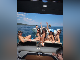 A lively group of friends enjoys a fun day on the water, celebrating and relaxing on a boat — the perfect summer getaway.