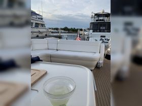 A cozy lounge area on a boat featuring comfortable seating and a refreshing drink, perfect for relaxing while enjoying the marina views.