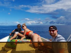 A joyful family enjoys a sunny day on the water, with smiles and laughter as they take in the beautiful ocean views from their boat.