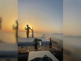 A silhouette of a man enjoying a drink at sunset on a yacht, creating a perfect backdrop for celebrations and memorable moments on the water.
