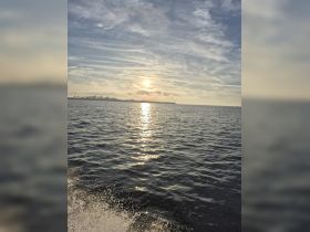 A stunning sunset reflects on the water, creating a picturesque scene perfect for evening boat rides and tranquil moments on the water.