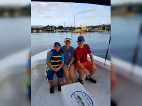 A joyful family poses together on a boat, showcasing a fun day on the water with kids wearing life jackets — perfect for family outings and adventures.