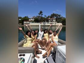A joyful group of friends celebrates together on a boat, showcasing the perfect summer outing with smiles and sunny vibes.