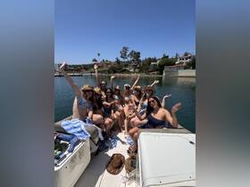 A lively group of friends celebrates on a boat, enjoying the sun and water — perfect for summer parties and memorable outings.