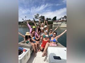 A lively group of friends celebrates on a pontoon boat, enjoying the sun and each other's company — perfect for summer parties and memorable outings on the water.