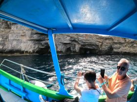 Guests capture the stunning cave entrance while enjoying a boat tour, making for a memorable adventure on the water.