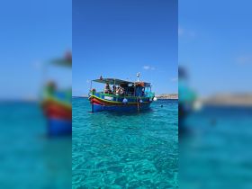 A vibrant boat with guests enjoying the beautiful turquoise waters, perfect for a day of adventure and relaxation on the sea.