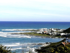 A scenic view of the coastline with waves and houses, but the image is unclear and lacks detail.