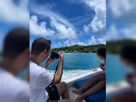 A family enjoys a boat ride, capturing scenic views with a camera — a perfect moment of adventure and togetherness on the water.