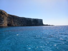 A stunning view of a rugged coastline against the vibrant blue ocean, capturing the beauty of nature and ideal for scenic boat trips.