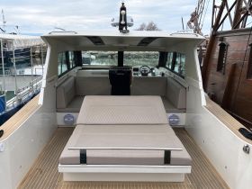The interior of a modern boat showcases a spacious seating area and helm, perfect for relaxation and navigation while enjoying time on the water.