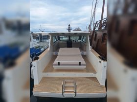 Interior view of a modern boat showcasing the helm and seating area, perfect for comfortable cruising and relaxation on the water.