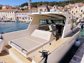 A spacious interior view of a modern boat featuring comfortable seating and a stylish cabin design, perfect for relaxing on the water.