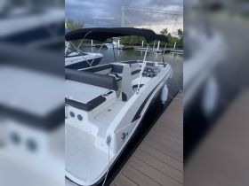 A sleek view of the interior seating and helm of a boat, showcasing its modern design and comfortable layout, perfect for a day on the water.