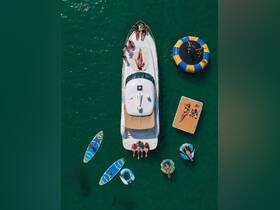 A lively group enjoys a fun day on the water with paddleboarding, lounging on a yacht, and playing on a water trampoline — the perfect summer getaway.