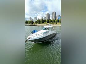 A sleek speedboat navigates through calm waters, showcasing its elegant design against a backdrop of urban skyline and lush greenery.