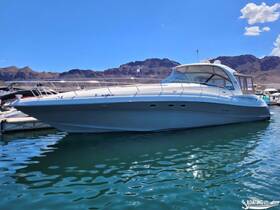A sleek speedboat docked in clear waters, showcasing its elegant design against a backdrop of rugged mountains — perfect for luxury outings on the water.
