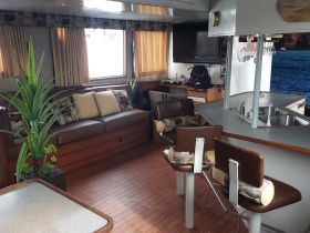 Interior view of a cozy boat cabin featuring comfortable seating and a well-equipped lounge area, perfect for relaxing during your nautical adventures.