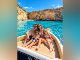 A joyful family enjoys a sunny day on a boat, surrounded by stunning turquoise waters and rocky cliffs — perfect for memorable family adventures.
