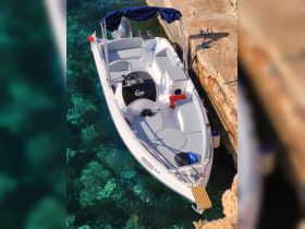 A sleek speedboat named 'Gaia' docked in crystal-clear waters, showcasing its modern design and comfortable seating — perfect for a day out on the water.