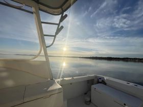 A serene view from the helm of a boat, capturing the tranquil waters and a beautiful sunset — perfect for peaceful cruising experiences.