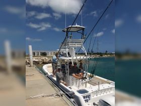 A group of friends prepares for a fishing adventure aboard a well-equipped boat at the dock, showcasing camaraderie and excitement for a day on the water.
