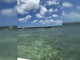 A picturesque view of boats cruising through clear turquoise waters under a bright blue sky, capturing the essence of a perfect day on the water.