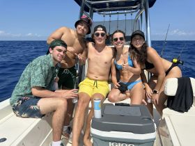 A lively group of friends enjoys a day out on the water, capturing fun moments aboard a boat under the sun.