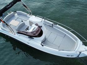 An aerial view of the spacious interior of a Marinello boat, showcasing comfortable seating and a well-equipped helm, perfect for leisurely outings on the water.