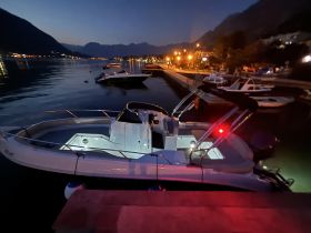 A sleek speedboat docked at night, illuminated by soft lights, showcasing the tranquil marina atmosphere.