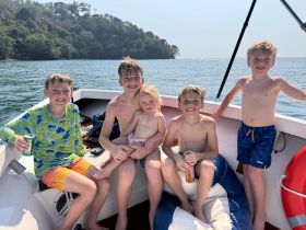 A joyful group of children enjoying a sunny day on a boat, creating unforgettable memories on the water.