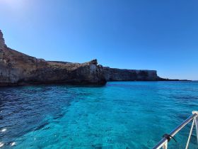 A stunning view of a rocky coastline against clear turquoise waters, perfect for showcasing the natural beauty of the area during a boat trip.