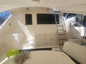 Interior view of a boat's cabin featuring seating and a staircase, showcasing a clean and spacious design ideal for relaxation and navigation.