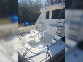 A spacious interior view of a boat's deck area featuring seating and a table, perfect for relaxing and enjoying the water.
