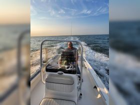 A man navigates a boat during a beautiful sunset, showcasing the joy of on-water adventures.