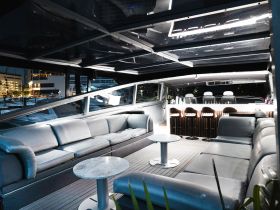A stylish interior view of a boat lounge area featuring sleek seating and a bar, perfect for relaxing and entertaining guests on the water.