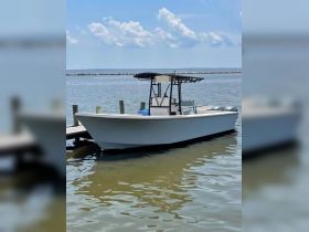 A sleek speedboat docked at the pier, showcasing its clean lines and inviting design, perfect for a day on the water.