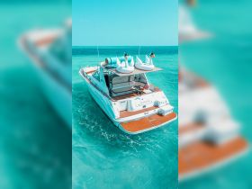 A stunning aerial view of a luxurious yacht named 'Seamint' anchored in crystal-clear waters, adorned with playful swan floaties — perfect for summer fun in Miami.