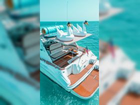 A luxurious boat deck featuring inflatable swan floats and a cooler, perfect for a relaxing day on the water in Miami.
