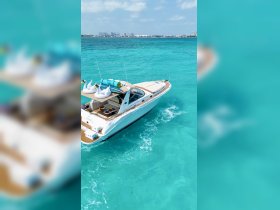 A stunning aerial view of a luxurious yacht cruising through crystal-clear turquoise waters, showcasing its elegant design and inviting deck space.