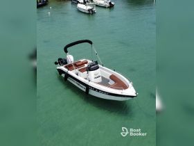 A sleek speedboat anchored in clear turquoise waters, perfect for a day of adventure on the water. Ideal for rentals and exploring coastal destinations.