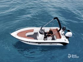 A person enjoys a leisurely ride on a sleek boat in clear blue waters, showcasing the perfect setting for a day of adventure on the sea.