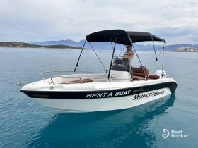 A man operates a rental boat in serene waters, showcasing the perfect setting for fishing trips and leisure on the water.