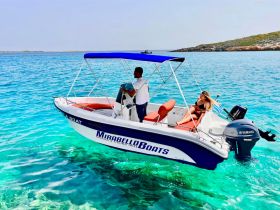 A couple enjoys a sunny day on a boat in crystal-clear waters, perfect for a relaxing getaway or adventure on the sea.