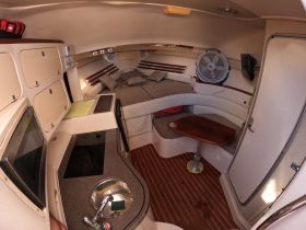 Interior view of a cozy boat cabin featuring comfortable seating and a well-equipped galley, perfect for relaxing during a day on the water.