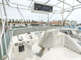 The interior helm of a boat showcases the steering console and seating area, perfect for navigating the waters in style.